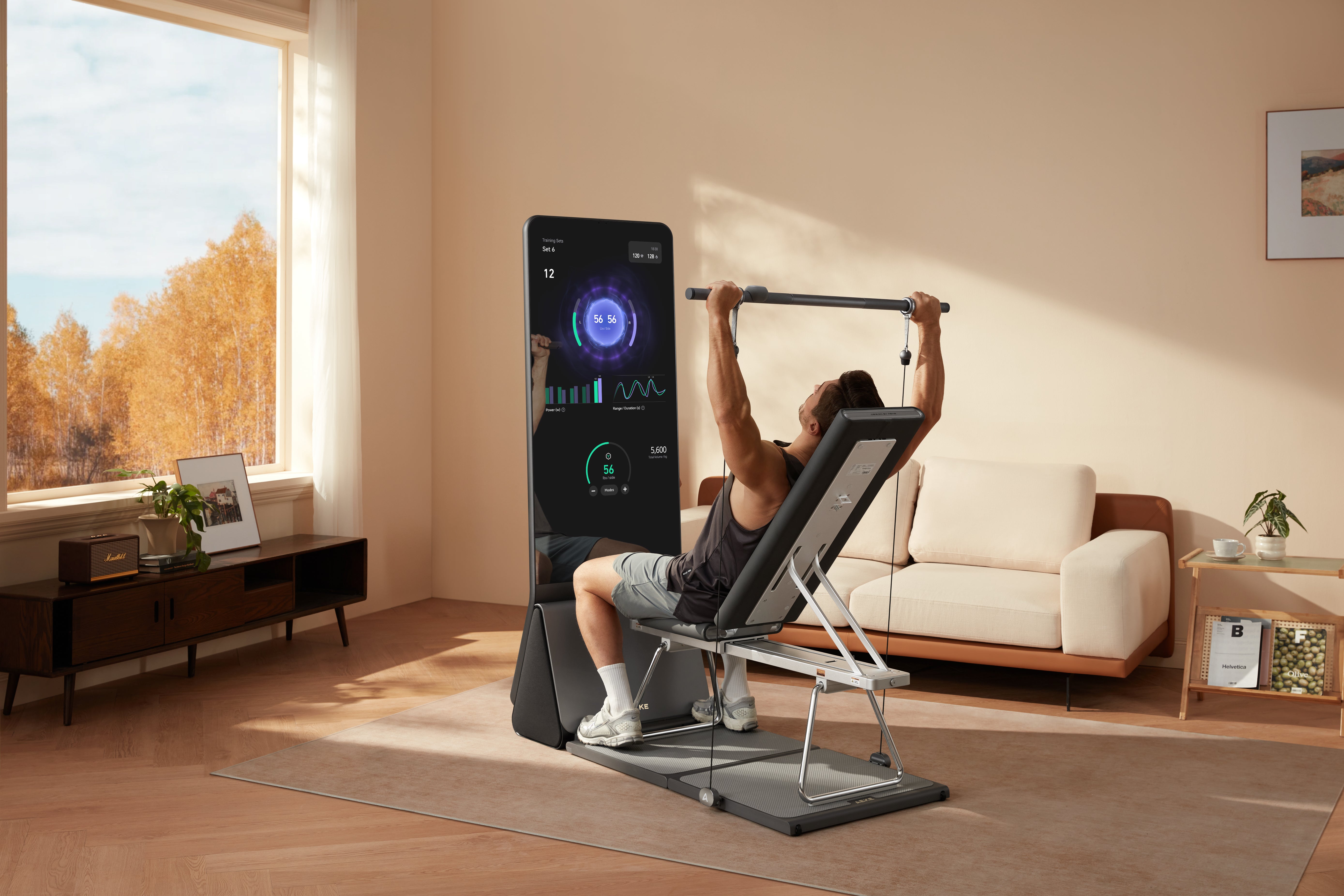 A man performing a seated strength training exercise using a smart mirror home gym system.