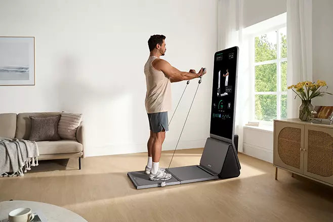 A man performing a cable workout on a digital home strength training machine.